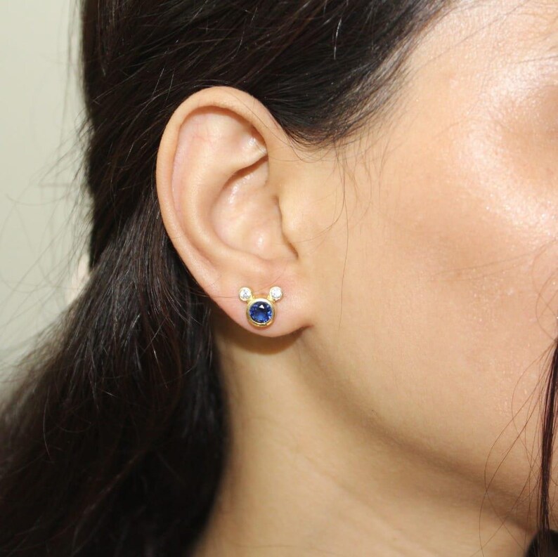 Minimalist gold earrings featuring deep blue cubic zirconia and crystal accents. Modern handmade studs by JewelsMinimal for daily use or parties.
 CZ earrings, minimalist jewelry, gold studs, handmade earrings, blue stone