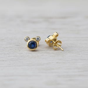 Cute mouse-inspired blue CZ earrings with gold plating and clear stones. Petite minimalist studs by JewelsMinimal for everyday charm.
 cute earrings, CZ studs, gold jewelry, minimal style, blue crystal earrings