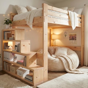 Peut inclure: Un lit mezzanine en bois avec un escalier et des étagères intégrés. Le lit est garni de literie blanche et d'une couverture crème. Un pouf et un tapis sont placés sous le lit. La pièce est décorée de plantes et de guirlandes lumineuses. Le lit mesure environ 190 cm de long.