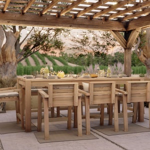 Op de afbeelding: Een houten eettafelset voor buiten met een rechthoekige tafel en zes stoelen. De tafel en stoelen zijn gemaakt van natuurlijk hout en hebben een rustieke afwerking. De set staat onder een houten pergola met lichtslingers.