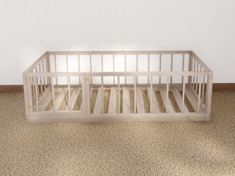 May include: A wooden crib frame with a slatted base and a removable side panel. The crib is made of natural wood and has a simple, classic design.