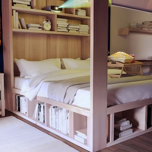 May include: A wooden bed frame with built-in shelves and storage compartments. The bed has a white duvet and pillows. A projector is mounted on the ceiling, projecting a movie onto the wall. A bowl of popcorn is on a small table next to the bed.