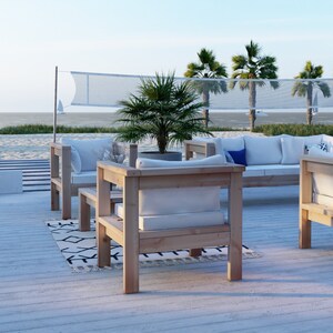 Puede incluir: Un conjunto de muebles de exterior de madera con cojines blancos. El conjunto incluye un sof&aacute;, dos sillones y una mesa de centro. Los muebles est&aacute;n en una terraza de madera con vistas a una playa y palmeras.