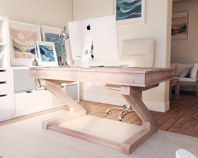 Puede incluir: Un escritorio de madera clara con una base en forma de Z y un monitor de computadora blanco en la parte superior. El escritorio est&aacute; en una oficina en casa con una alfombra blanca y pisos de madera.
