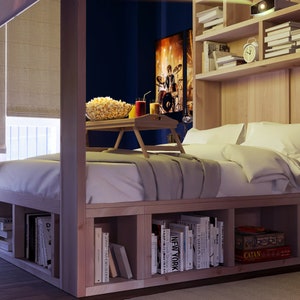 May include: A wooden bed frame with built-in shelves for storage. The bed has a white comforter and two pillows. There is a tray on the bed with popcorn and drinks.