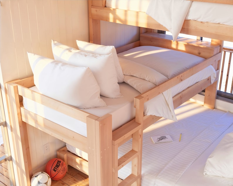 May include: A wooden bunk bed with white bedding and pillows. The top bunk has a white sheet and a white pillow. The bottom bunk has a white sheet, a white pillow, and a white blanket. There is a basketball on the floor next to the bed.