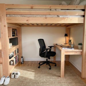 May include: A light-colored wooden loft bed with a built-in desk, bookcase, and stairs. The bed frame is made of thick, unfinished wood. A black office chair sits at the desk. The room has a neutral color palette with a woven rug.