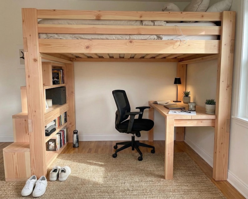 May include: A light-colored wooden loft bed with a built-in desk, bookcase, and stairs. The bed frame is made of thick, unfinished wood. A black office chair sits at the desk. The room has a neutral color palette with a woven rug.