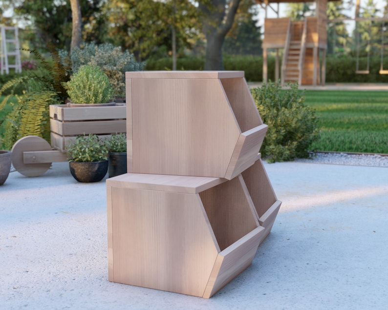 May include: Three wooden storage bins stacked on top of each other. The bins are made of light wood and have a hexagonal shape. The bins are sitting on a light gray surface.