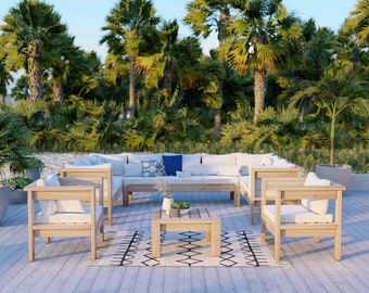 May include: A wooden outdoor sectional sofa with white cushions and a matching coffee table. The sofa is set on a wooden deck with a patterned rug. The background features a lush tropical landscape with palm trees.