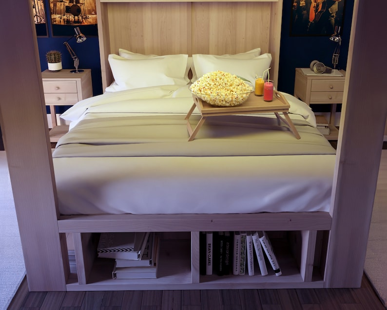 May include: A wooden bed frame with a white bedspread and pillows. A wooden tray with a bowl of popcorn and two glasses sits on the bed. The bed has built-in shelves underneath for storage.