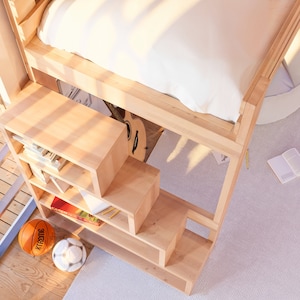 Puede incluir: Una litera de madera con una estanter&iacute;a y escalones incorporados. La cama est&aacute; hecha de madera clara y tiene un colch&oacute;n blanco. La estanter&iacute;a tiene varios estantes y est&aacute; llena de libros y otros objetos. Los escalones est&aacute;n hechos del mismo tipo de madera que la cama y tienen un dise&ntilde;o sencillo.