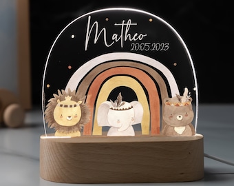 May include: A wooden night light with a clear acrylic panel featuring a rainbow, a lion, an elephant, and a bear. The panel also has the name "Matheo" and the dates "2005 2023" written on it.