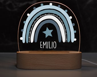 May include: A blue and white rainbow night light with a star and the name "EMILIO" on a wooden base.