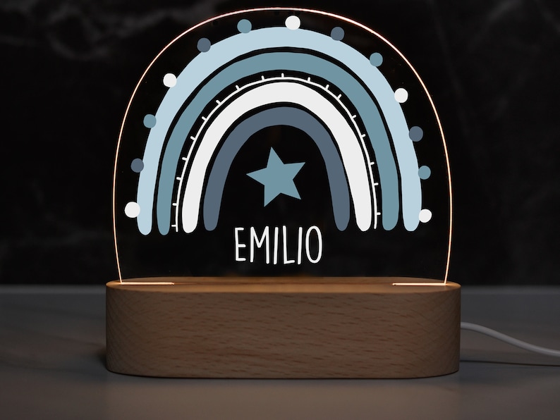 May include: A blue and white rainbow night light with a star and the name "EMILIO" on a wooden base.