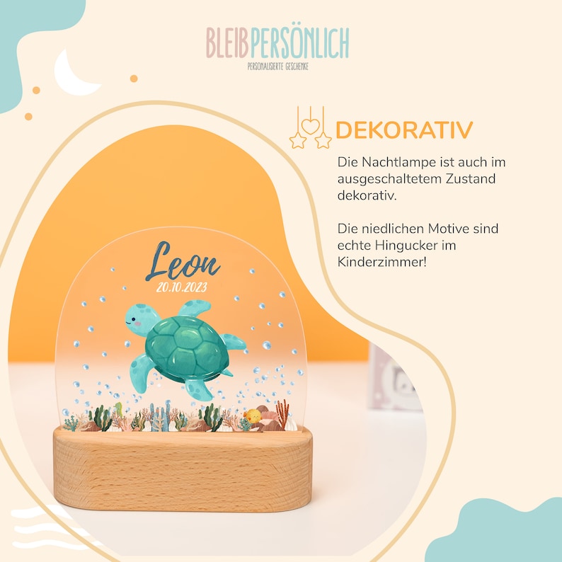 Op de afbeelding: Een gepersonaliseerde nachtlamp met een houten voet en een transparante koepel. De koepel heeft een illustratie van een zeeschildpad en de naam "Leon" met de datum "20.10.2023". De tekst "DEKORATIV" is zichtbaar in de rechterbovenhoek van de afbeelding.