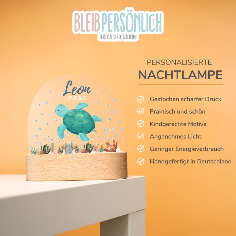 Op de afbeelding: Een gepersonaliseerd nachtlampje met een houten voet en een transparante koepel. De koepel heeft een cartoon zeeschildpad en de naam "Leon" met de datum "20.10.2023". De tekst "BLEIB PERSONLICH PERSONALISIERTE GESCHENKE" staat bovenaan de afbeelding. De tekst "PERSONALISIERTE NACHTLAMPE" staat rechtsboven in de afbeelding. Onder de tekst staat een lijst met kenmerken, waaronder "Gestochen scharfer Druck", "Praktisch und sch&ouml;n", "Kindgerechte Motive", "Angenehmes Licht", "Geringer Energieverbrauch" en "Handgefertigt in Deutschland".