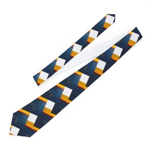 Puede incluir: Una corbata con un patrón repetitivo de rectángulos blancos, rayas amarillas y naranjas, y un fondo azul oscuro. La corbata está hecha de una tela suave y se muestra sobre un fondo blanco.