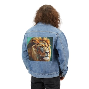 Puede incluir: Chaqueta vaquera azul claro con un vibrante retrato de león en la espalda. La melena del león es de un rico color dorado, sobre un fondo turquesa. La chaqueta tiene un diseño clásico con botones y bolsillos.