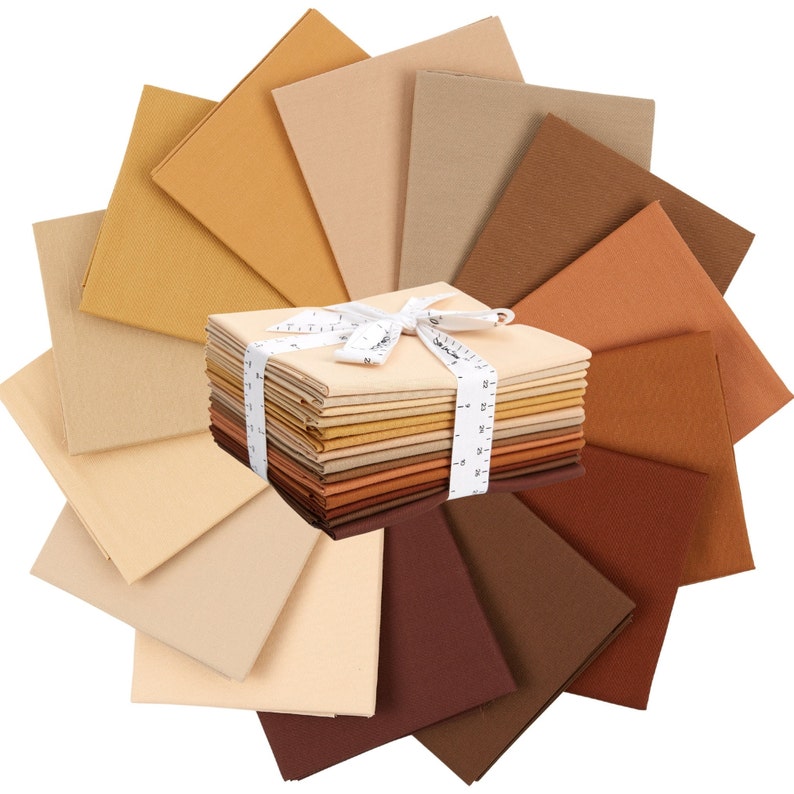 May include: A stack of 20 fabric squares in various shades of brown, beige, and tan. The fabric squares are arranged in a fan shape, with the stack of fabric squares in the center.
