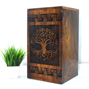 May include: A wooden box with a carved tree of life design. The box is dark brown with a black stain and has a hinged lid.