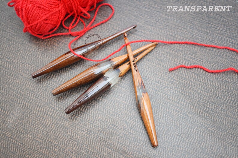 K&ouml;nnte beinhalten: Drei Stricknadeln aus Holz mit rotem Garn. Die Nadeln sind 3,5 mm, 4,0 mm und 6,5 mm.