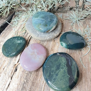 Puede incluir: Cinco piedras lisas y pulidas en tonos de verde, rosa y blanco. Las piedras tienen forma ovalada y tienen un aspecto natural y orgánico.