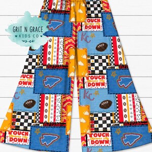 May include: Wide-leg pants featuring a patchwork design with red, yellow, and blue colors. Patterns include footballs, stars, checkerboards, and the text "TOUCH DOWN" and "Kansas City". The fabric has an elastic waistband and a loose fit.