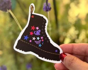 May include: Black leather boot with colorful stars and butterflies. The boot has a yellow stitching detail around the sole.