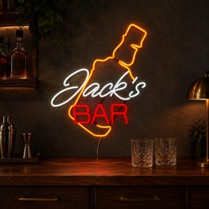 Può includere: Un'insegna al neon con il contorno arancione di una bottiglia di liquore, il testo in corsivo bianco Jack's e il testo in stampatello rosso BAR. L'insegna è montata su una parete scura sopra un bancone in legno con due bicchieri trasparenti.