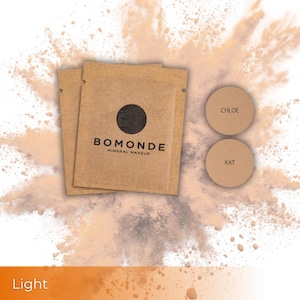 May include: Two brown paper packets with the text "BOMONDE MINERAL MAKEUP" and a black circular logo. Two round, light brown makeup samples are labeled "CHLOE" and "KAT". The word "Light" is at the bottom of the image.
