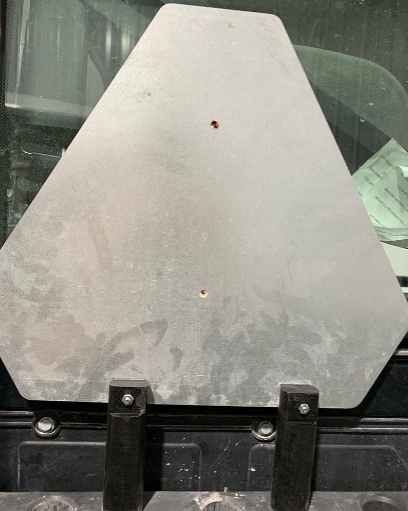 May include: A silver metal triangle shaped sign with two black metal brackets attached to the bottom.