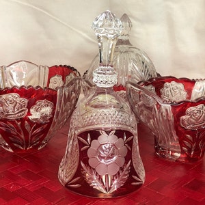 May include: Set of four clear glass bowls with red accents. The bowls are decorated with cut glass roses and have a scalloped edge.