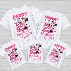 May include: White t-shirts with pink graphics featuring Minnie Mouse and the number 2. The shirts are labeled "Daddy", "Mommy", "Brother", "Sister", and "Birthday Girl". Hearts and polka dots complete the design.