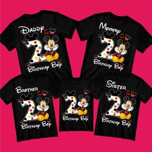 Puede incluir: Camisetas negras con dise&ntilde;os de Mickey Mouse. Cada camiseta tiene un gran n&uacute;mero "2" con lunares, Mickey Mouse y texto como "Daddy of the Birthday Boy". Ideal para una celebraci&oacute;n familiar.