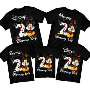Puede incluir: Camisetas negras con dise&ntilde;os de Mickey Mouse. Cada camiseta presenta un gran n&uacute;mero "2" con lunares, Mickey Mouse, y las palabras "Daddy of the", "Mommy of the", "Brother of the", "Sister of the", y "Birthday Boy".