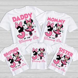 Op de afbeelding: Een set van vier witte T-shirts met een roze en zwart Minnie Mouse-ontwerp. De shirts zeggen "Papa", "Mama", "Broer" en "Zus" met het nummer "3" en de tekst "van het jarige meisje".