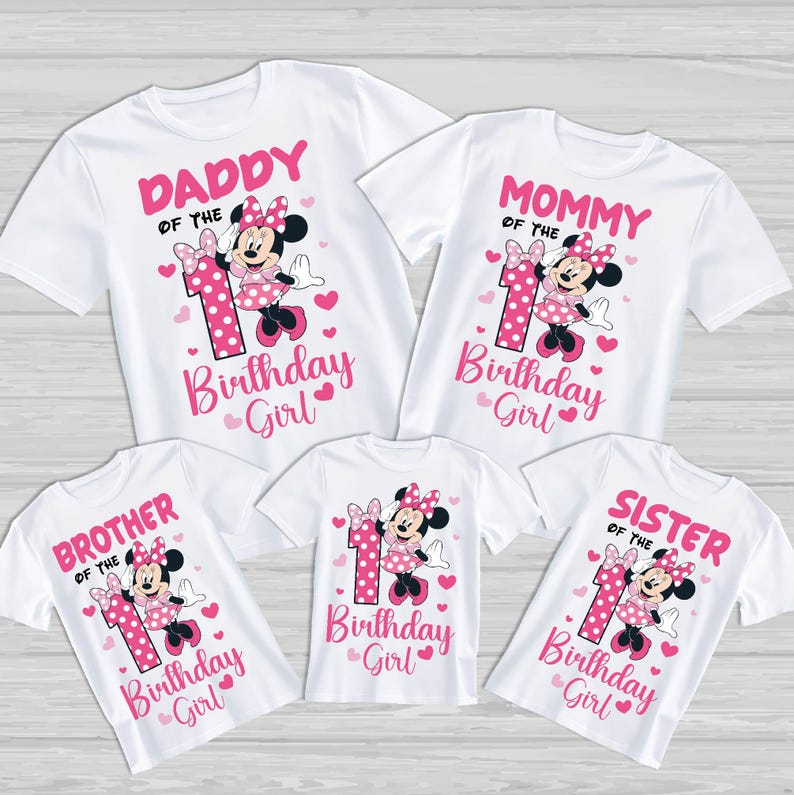 Puede incluir: Camisetas blancas con texto rosa y gr&aacute;ficos de Minnie Mouse. Las camisetas dicen "Pap&aacute;", "Mam&aacute;", "Hermano", "Hermana" y "Birthday Girl". Cada camiseta presenta un n&uacute;mero uno y acentos de coraz&oacute;n.