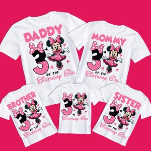 Op de afbeelding: Set van vijf witte T-shirts met een roze en zwart Minnie Mouse-ontwerp. De shirts zeggen "Papa", "Mama", "Broer", "Zus" en "3 van het verjaardagsmeisje".