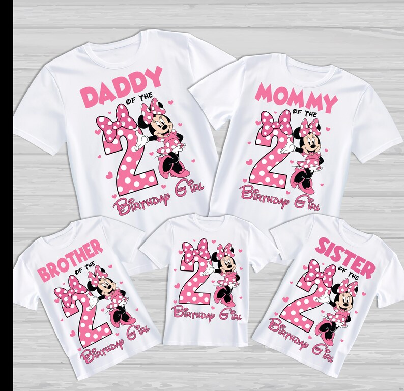 Może przedstawiać: Białe koszulki z r&oacute;żowymi grafikami Myszki Minnie, dużą cyfrą 2 oraz napisami "Daddy", "Mommy", "Brother", "Sister" i "Birthday Girl". Idealne na rodzinną uroczystość.