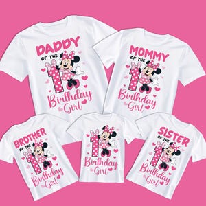 Puede incluir: Camisetas blancas con texto rosa y gr&aacute;ficos de Minnie Mouse. Las camisetas dicen "Pap&aacute;", "Mam&aacute;", "Hermano", "Hermana" y "Cumplea&ntilde;era". Cada camiseta presenta un n&uacute;mero uno y corazones.