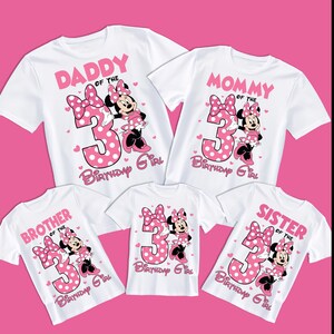 Puede incluir: Camisetas blancas con dise&ntilde;os de Minnie Mouse rosa para una familia. Cada camiseta presenta un gran n&uacute;mero 3 rosa con lunares blancos, Minnie Mouse y textos como "Pap&aacute;", "Mam&aacute;", "Hermano" y "Hermana" con "Cumplea&ntilde;era".