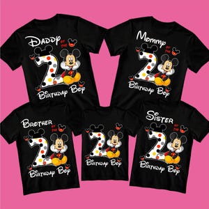 Puede incluir: Camisetas negras con dise&ntilde;os de Mickey Mouse para una familia. Cada camiseta tiene un n&uacute;mero 2 grande con lunares, Mickey Mouse y textos como "Daddy", "Mommy", "Brother" y "Sister" con "Birthday Boy".
