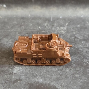 May include: A small, brown toy tank with detailed features, including a turret, gun, and treads. The miniature vehicle is made of plastic and sits on a grey surface. This toy tank is a model of a military vehicle.