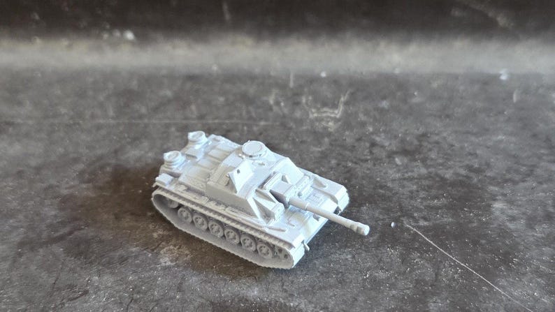 Puede incluir: Un modelo de tanque gris claro con un ca&ntilde;&oacute;n largo y orugas detalladas. El tanque en miniatura es una r&eacute;plica de un veh&iacute;culo militar, que muestra su dise&ntilde;o y caracter&iacute;sticas. El modelo est&aacute; hecho de un material s&oacute;lido.