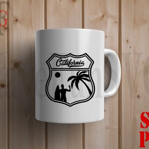 May include: White ceramic mug with a black and white graphic of a California road sign with palm trees and a surfer. The sign says "California".