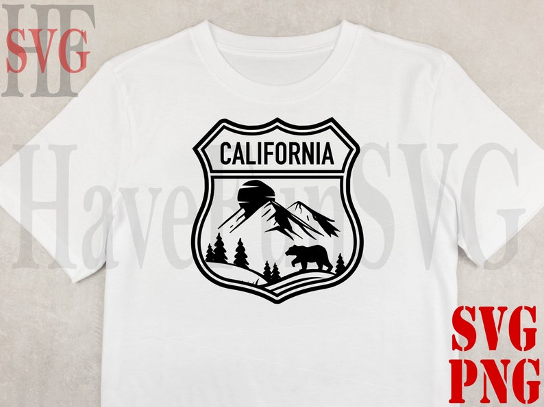 May include: A white t-shirt with a black and white graphic of a California state park emblem. The emblem features a mountain range, a bear, and the text "CALIFORNIA".
