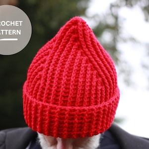 Puede incluir: Un gorro de punto de lana rojo con textura de canalé.