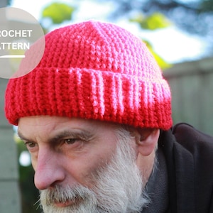 May include: A red and pink crocheted beanie hat with a fold-over brim.