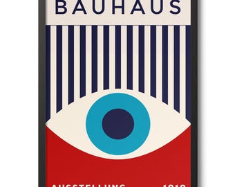 May include: Framed Bauhaus art print featuring a bold design with the word "BAUHAUS" at the top. The artwork includes vertical blue stripes, a large eye graphic, and the words "AUSSTELLUNG" and "1919" at the bottom. The frame is black.